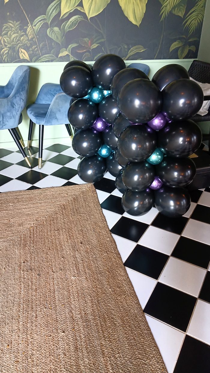 Arche de ballons noir et turquoise sur sol damier