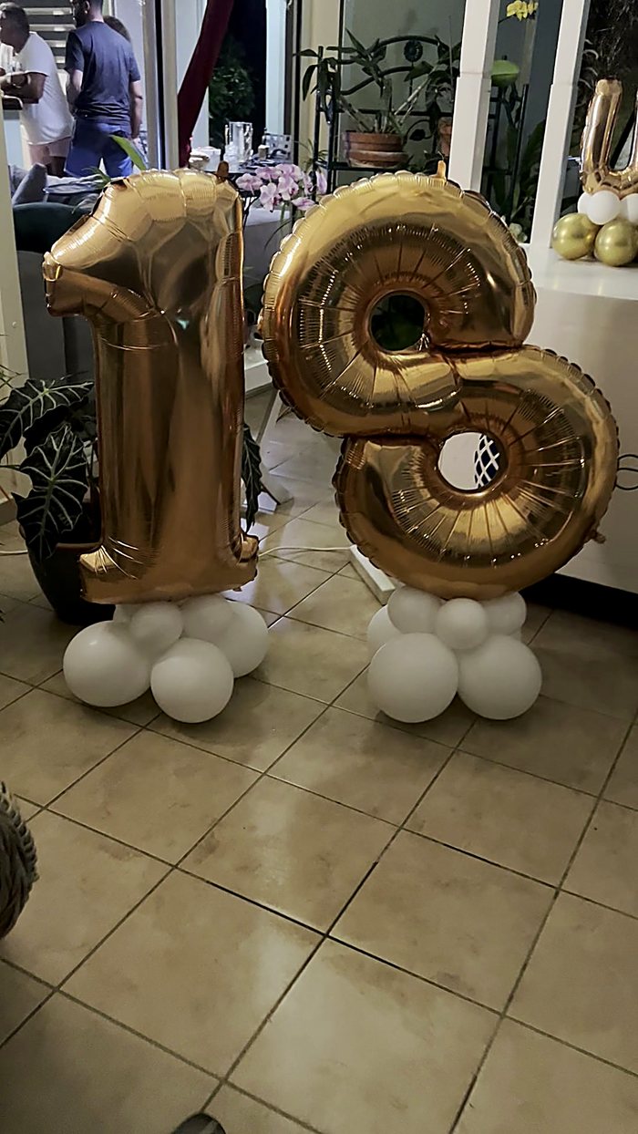 Chiffres dorés 18 et colonnes de ballons blancs pour un anniversaire