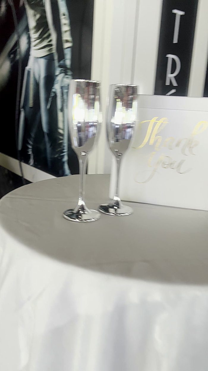 Table ronde nappée de blanc avec coupes de champagne, réception élégante