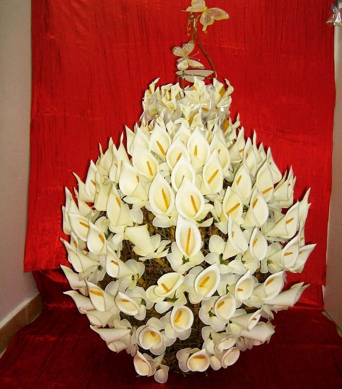 Pyramide de fleurs de arum blanches sur fond rouge