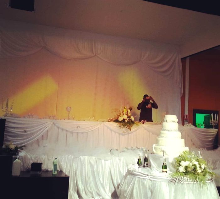 Salle drapée de blanc avec table à gâteau pour un mariage